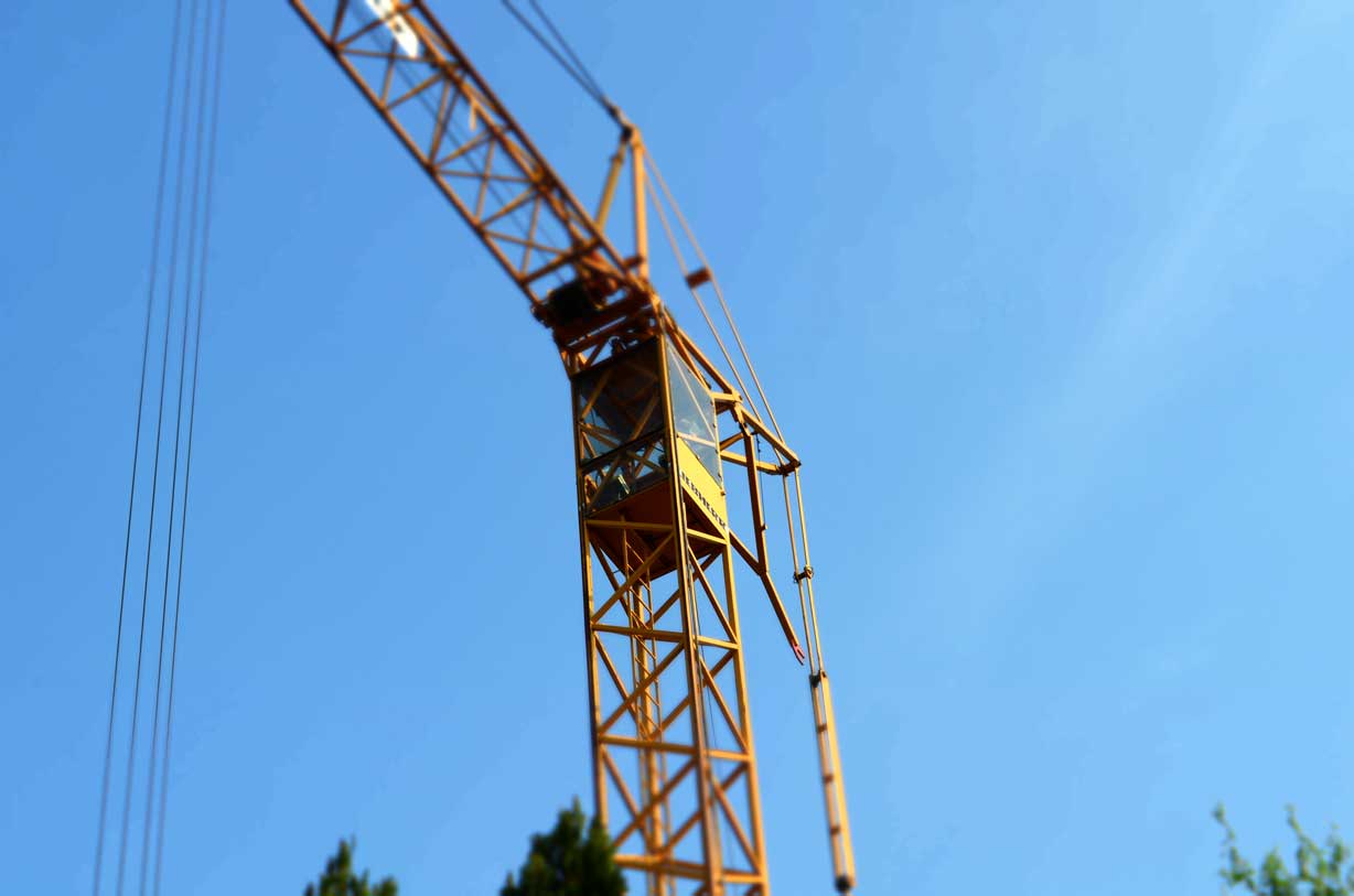 Neubau: Kran auf einer Baustelle für ein Mehrfamilienhaus